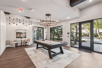 A room with a pool table and a chandelier